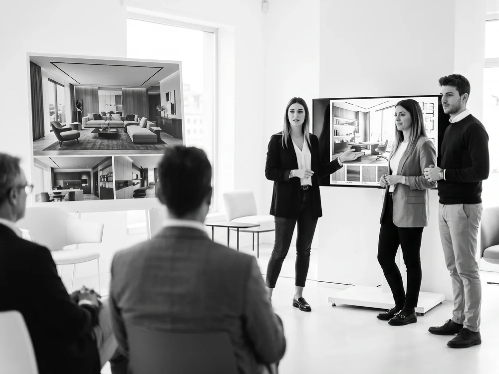 Team di progetto presenta una pianta tecnica a una giuria in uno studio di design